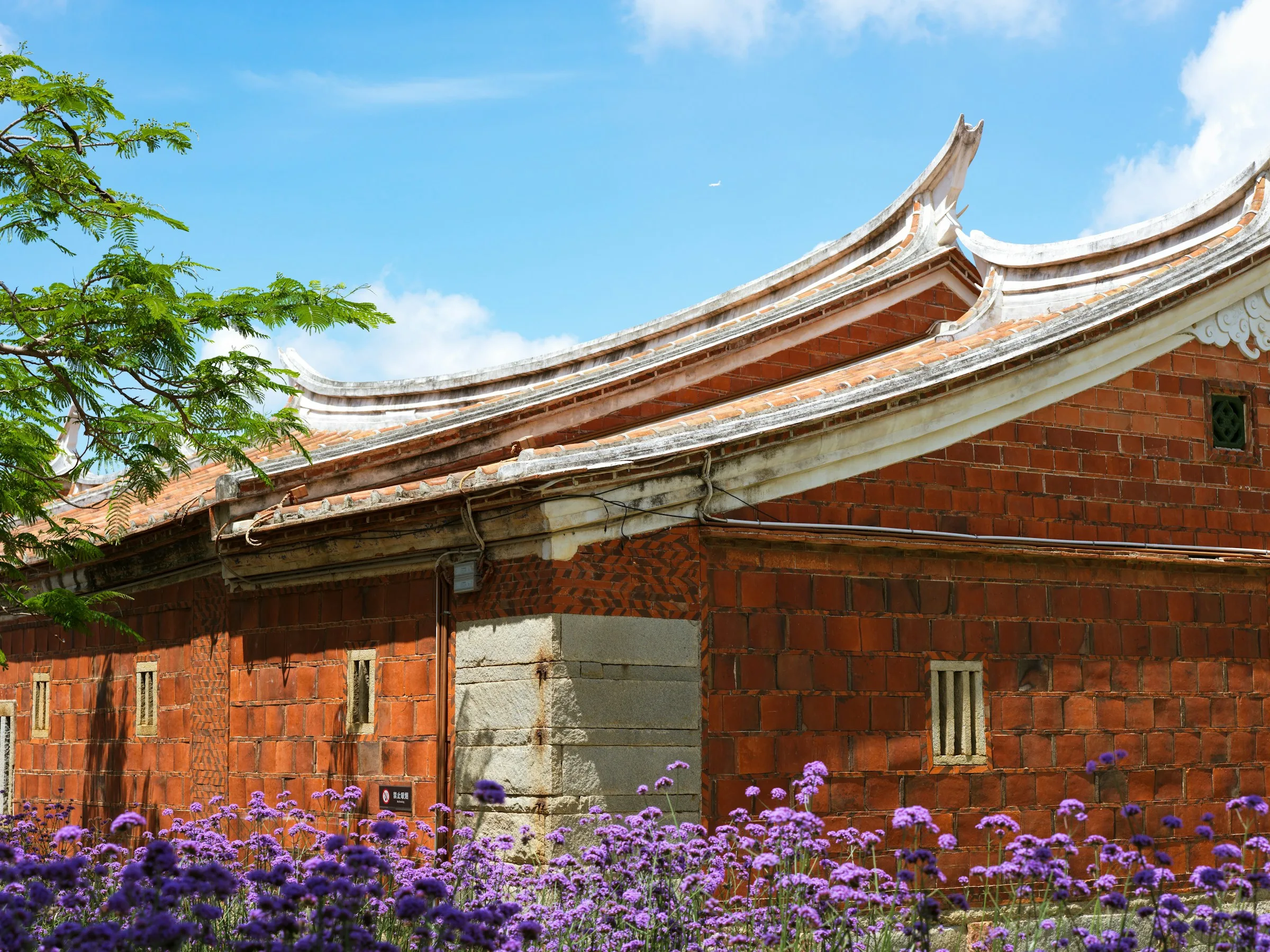 A traditional red building in Quanzhou with the curved roof of the Maritime Silk Road port city.